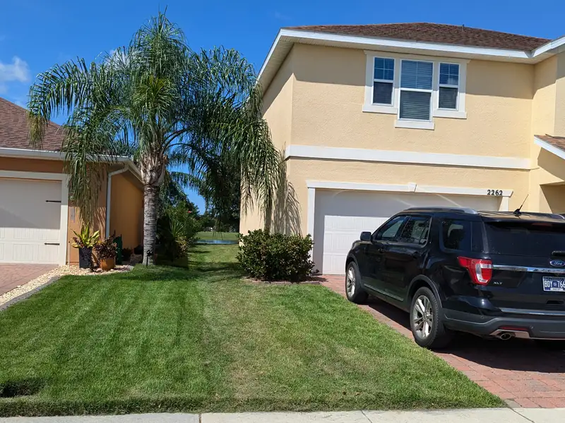 Crisply edged front lawn and driveway line at a two-storey home