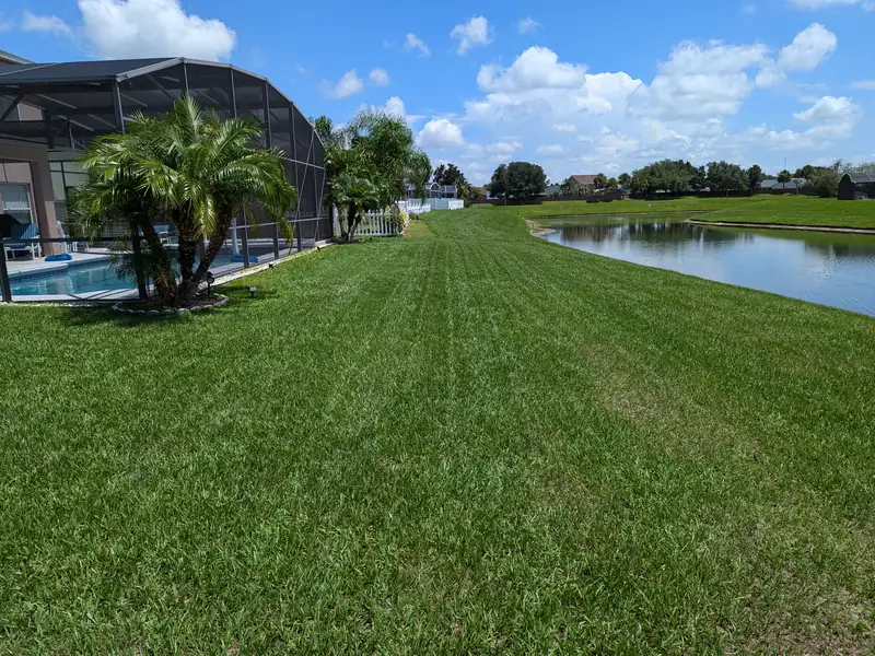 Long lakeside lawn mowed in straight stripes